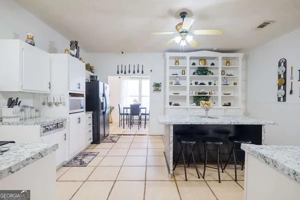 a kitchen with granite countertop a stove a sink and a refrigerator