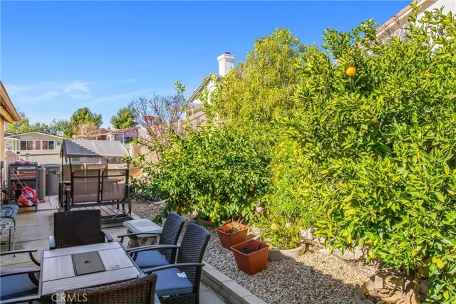 a view of a patio with table and chairs potted plants