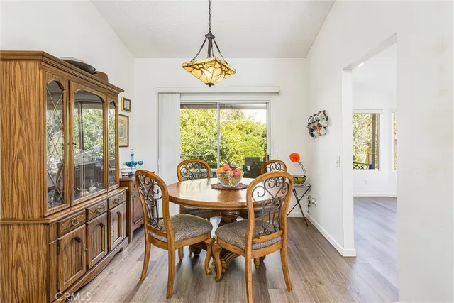 a dining room with furniture a chandelier and wooden floor
