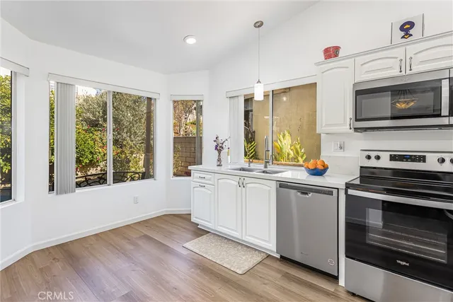 a kitchen with stainless steel appliances a stove a sink and a microwave