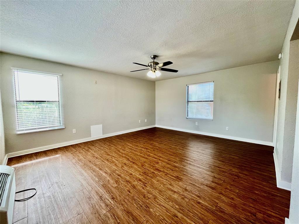 701 West Sycamore Street, Unit 209 Denton, TX 76201 - Photo 4 of 10 an empty room with wooden floor and windows