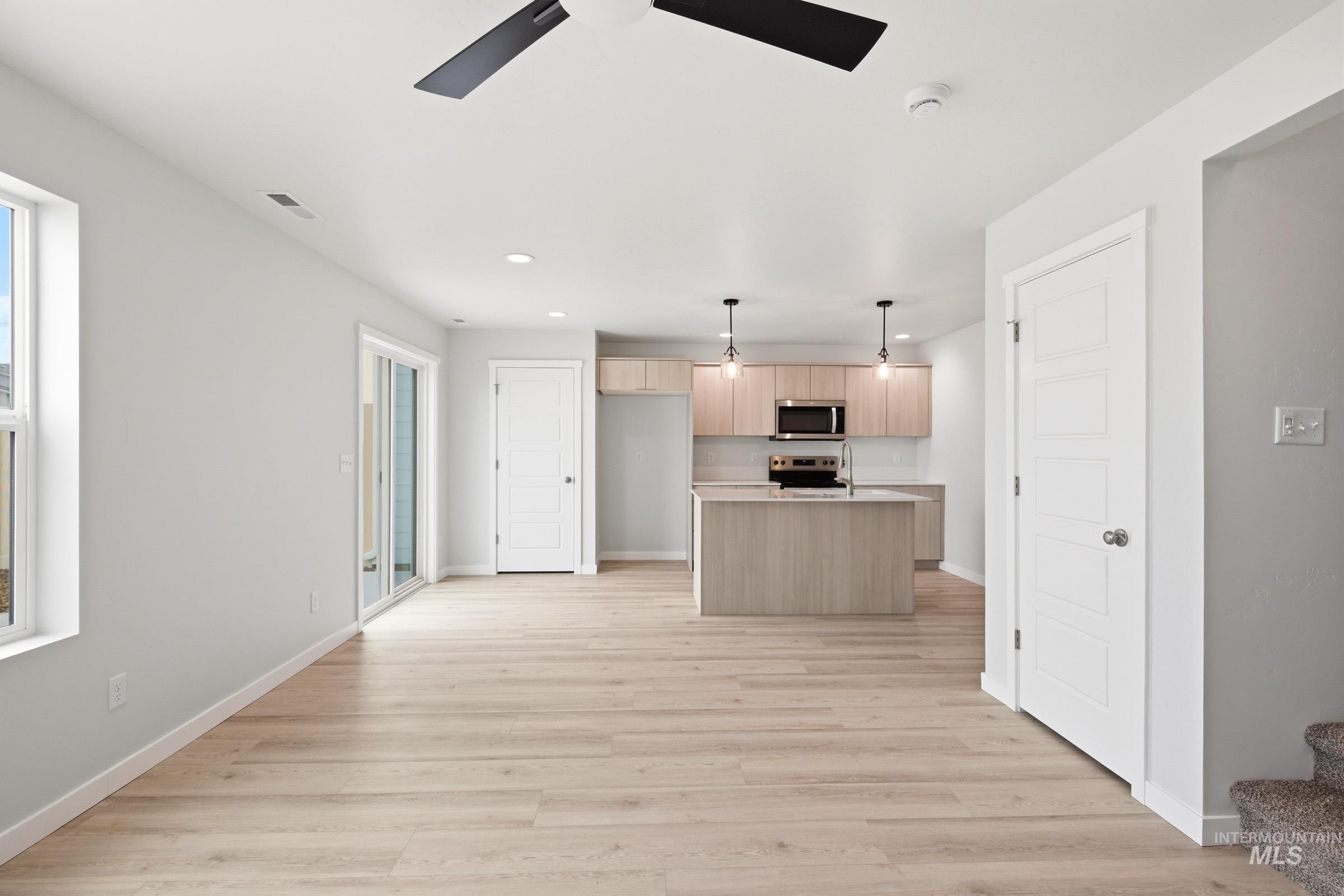 10776 Rutland Street Caldwell, ID 83605 - Photo 21 of 22 Kitchen with light countertops, light wood finish cabinets, ceiling fan, a center island with sink, and open floor plan