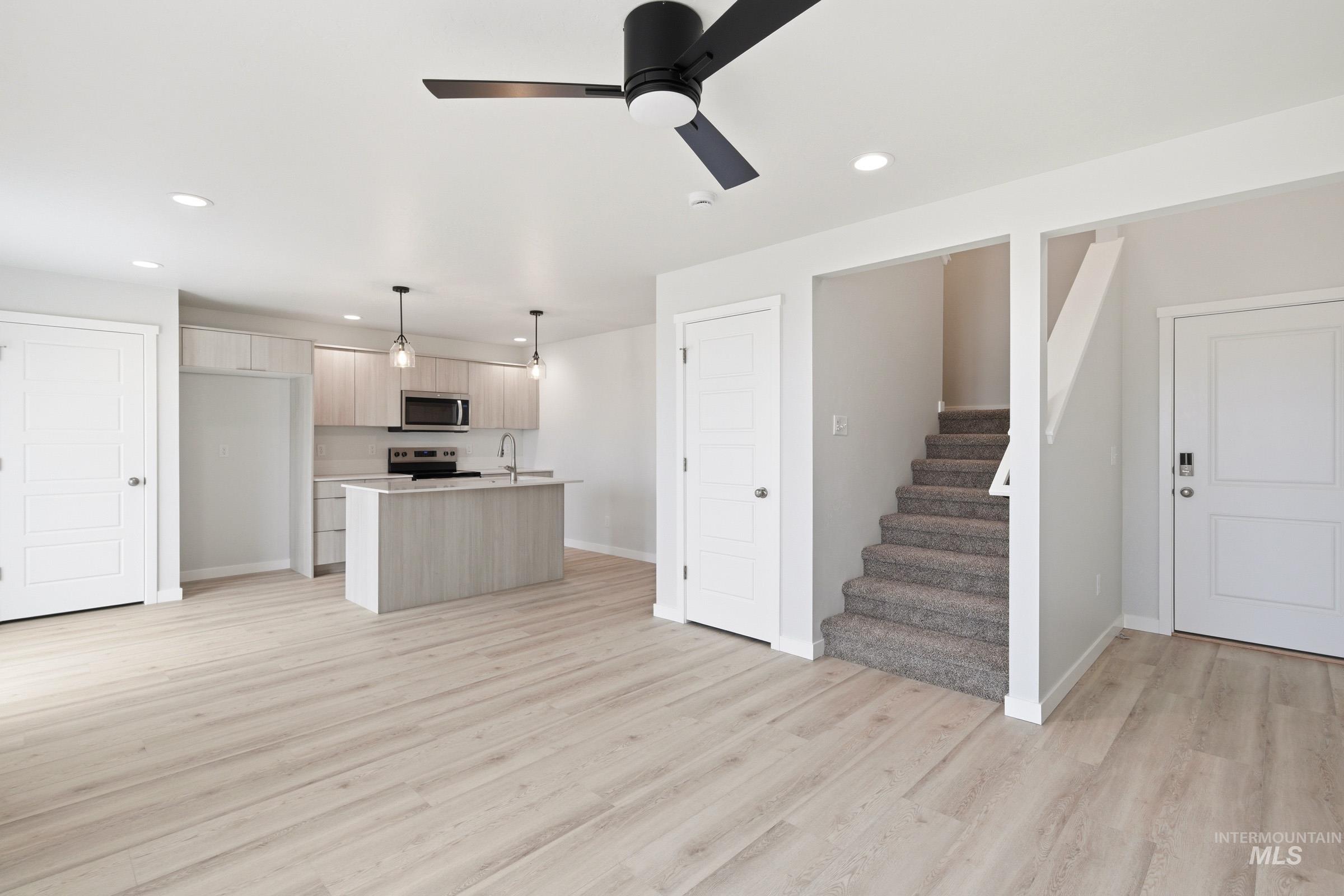 10776 Rutland Street Caldwell, ID 83605 - Photo 22 of 22 Kitchen featuring light countertops, open floor plan, light wood finish cabinets, hanging light fixtures, and stainless steel appliances