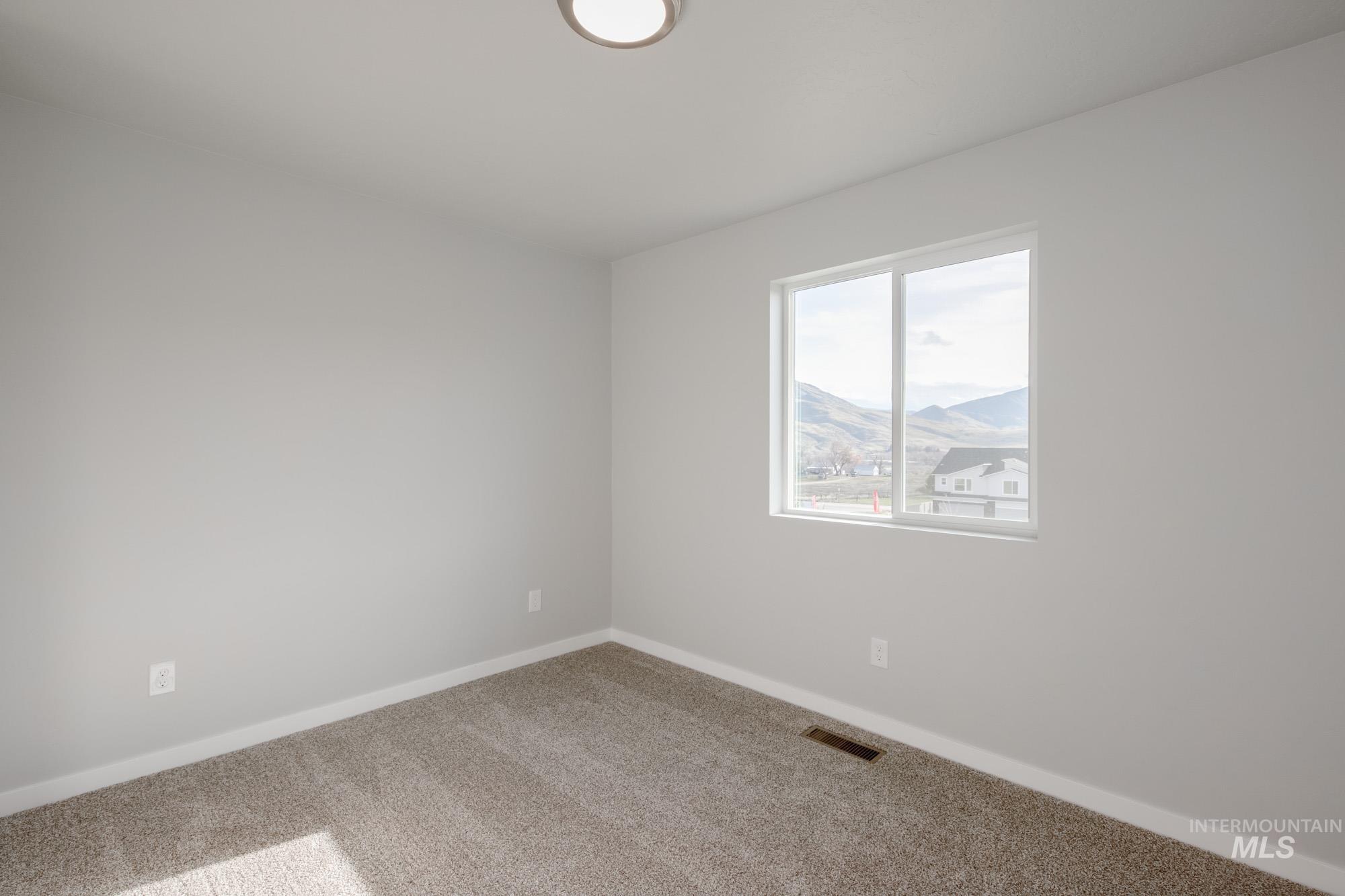 10776 Rutland Street Caldwell, ID 83605 - Photo 12 of 22 Carpeted spare room with baseboards and a mountain view