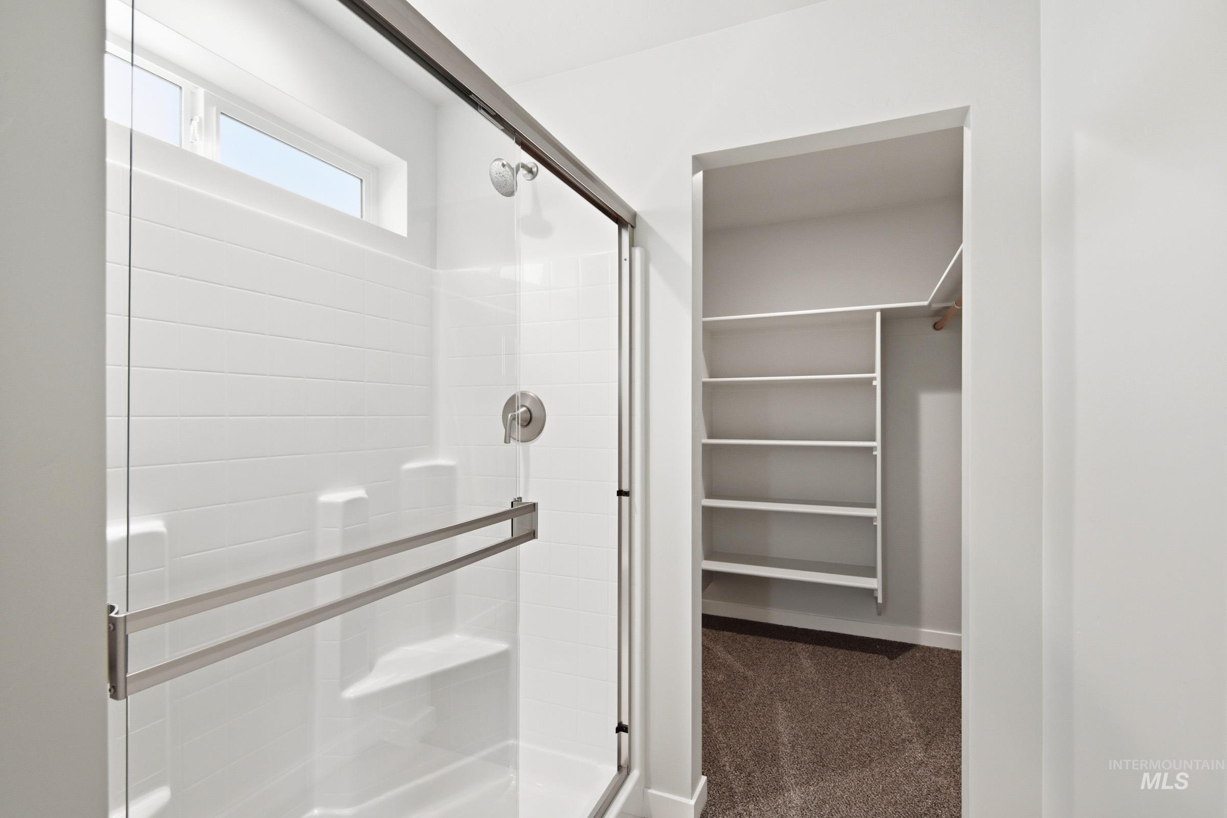 10776 Rutland Street Caldwell, ID 83605 - Photo 17 of 22 Full bathroom featuring a walk in closet, a stall shower, and dark colored carpet