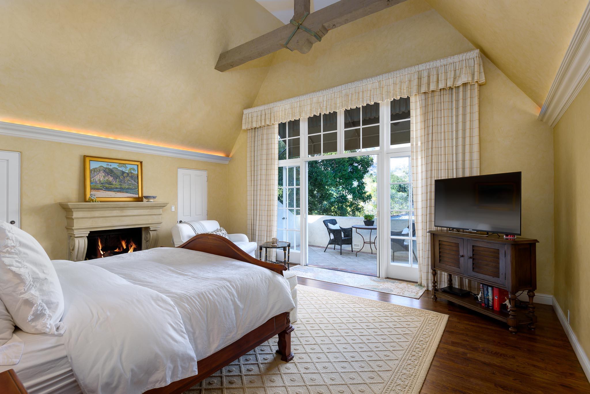 1570 East Valley Road Montecito, CA 93108 - Photo 7 of 23 a spacious bedroom with a balcony a bed and a flat screen tv