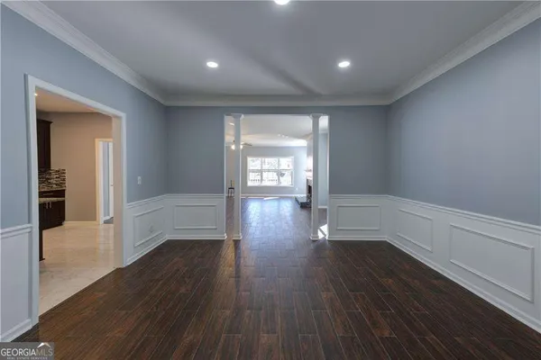 an empty room with wooden floor fireplace and windows