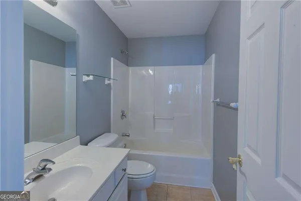 a white toilet sitting next to a shower