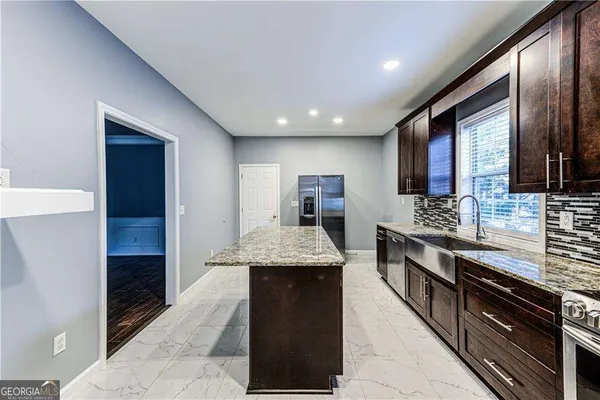 a large kitchen with stainless steel appliances granite countertop wooden cabinets a granite counter tops and a stove