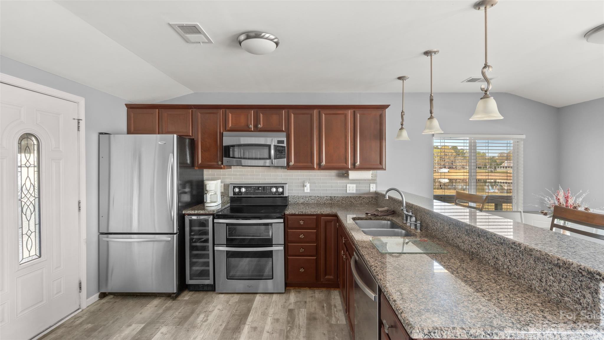 70 Rainbow Cove Ridgeway, SC 29130 - Photo 4 of 28 a kitchen with granite countertop a refrigerator a sink a stove and wooden floors