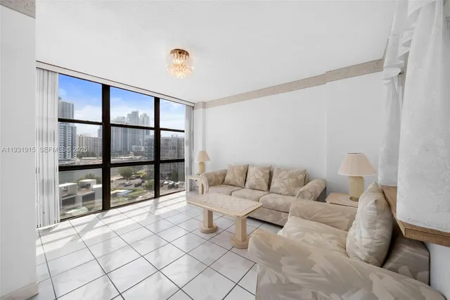 a living room with furniture and a floor to ceiling window