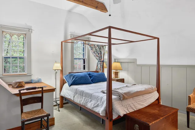 a bedroom with a bed a table and chair