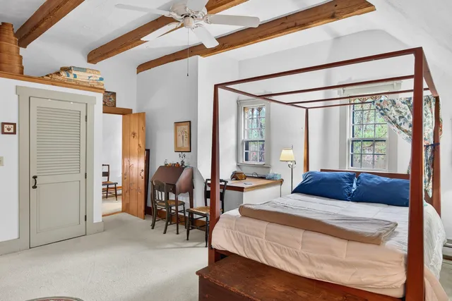 a bedroom with furniture and a large window