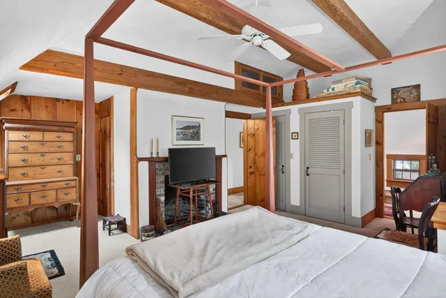 a bedroom with a bed window and a flat screen tv