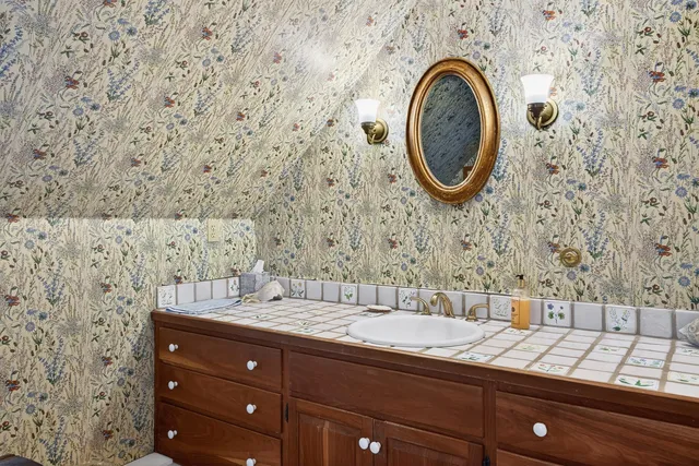 a bathroom with a granite countertop sink and a mirror