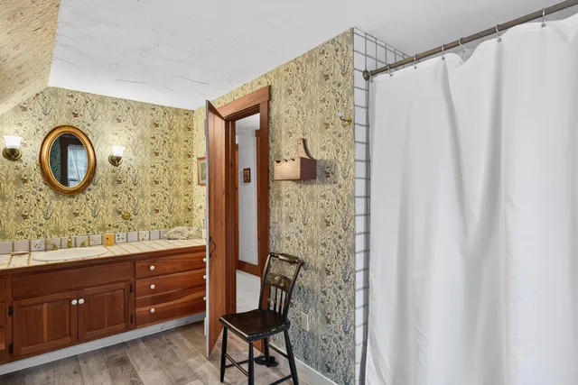 a bathroom with a granite countertop sink and a mirror