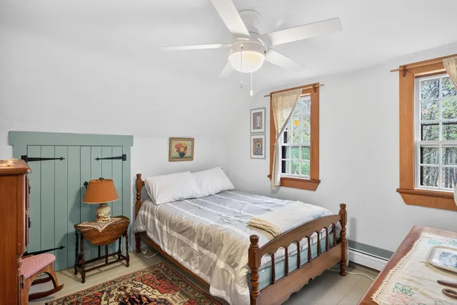 a bedroom with a bed a window and dresser