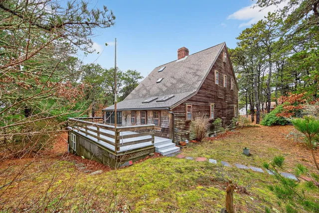 a view of a house with backyard and trees