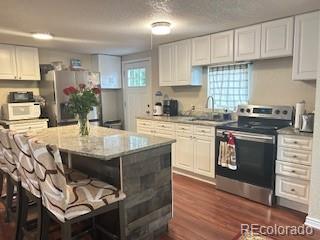 7115 Harold Street, Unit 2 Fort Lupton, CO 80621 - Photo 2 of 27 a kitchen with a stove a sink and cabinets