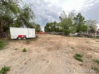 7115 Harold Street, Unit 2 Fort Lupton, CO 80621 - Photo 22 of 27 a white house with a yard and parking space