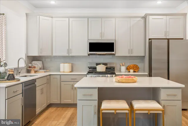 a kitchen with a sink stove and white cabinets