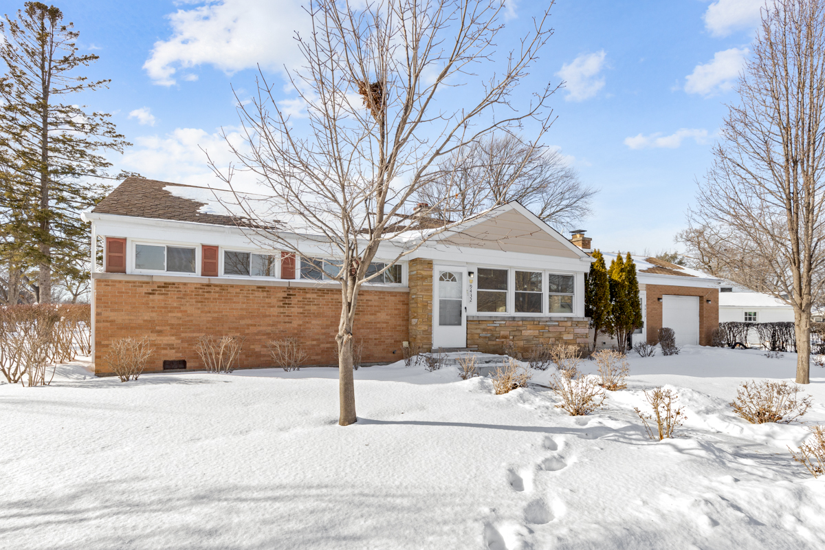 a front view of a house with a yard covered in snow