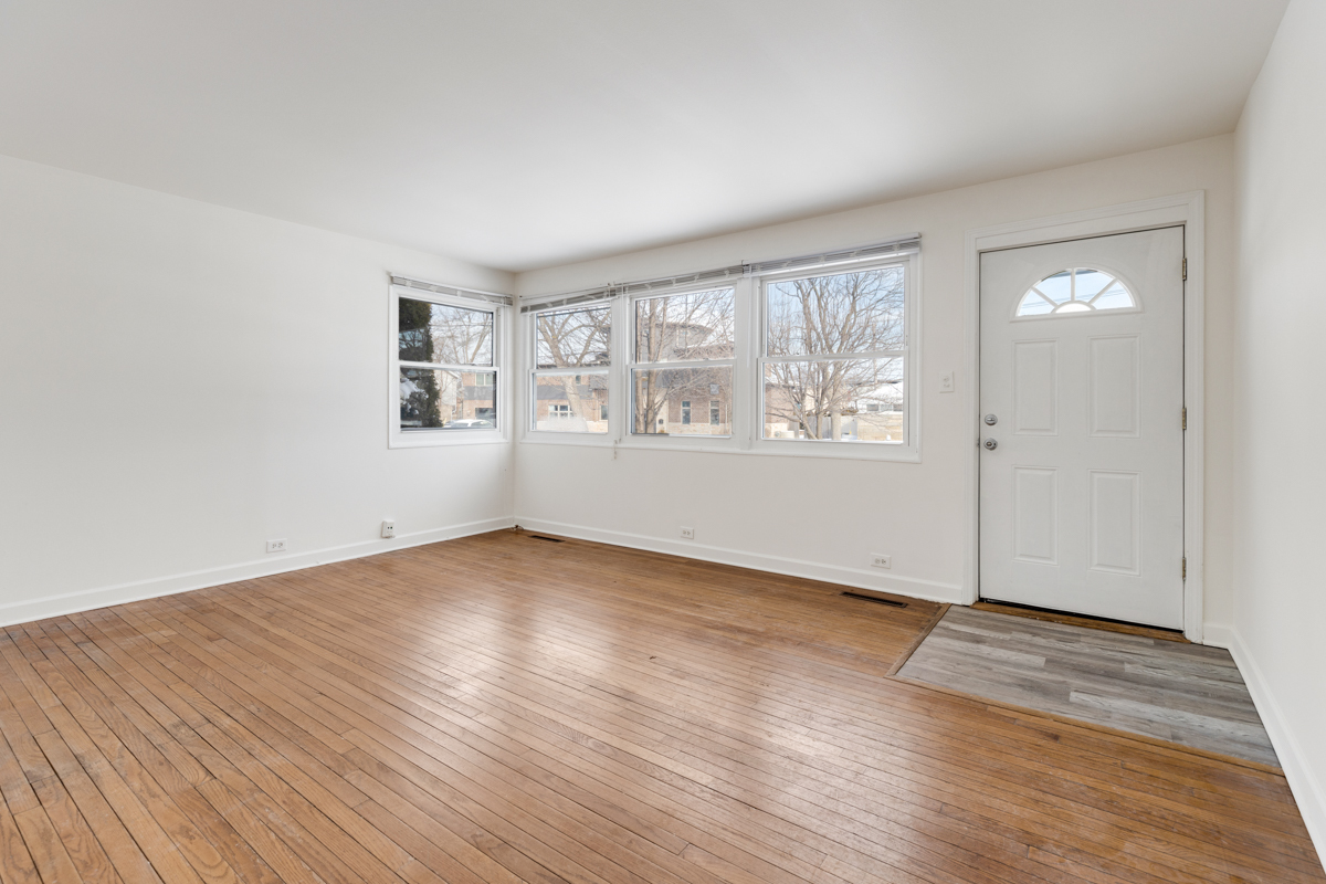 9432 Sayre Avenue Morton Grove, IL 60053 - Photo 2 of 20 an empty room with wooden floor and windows