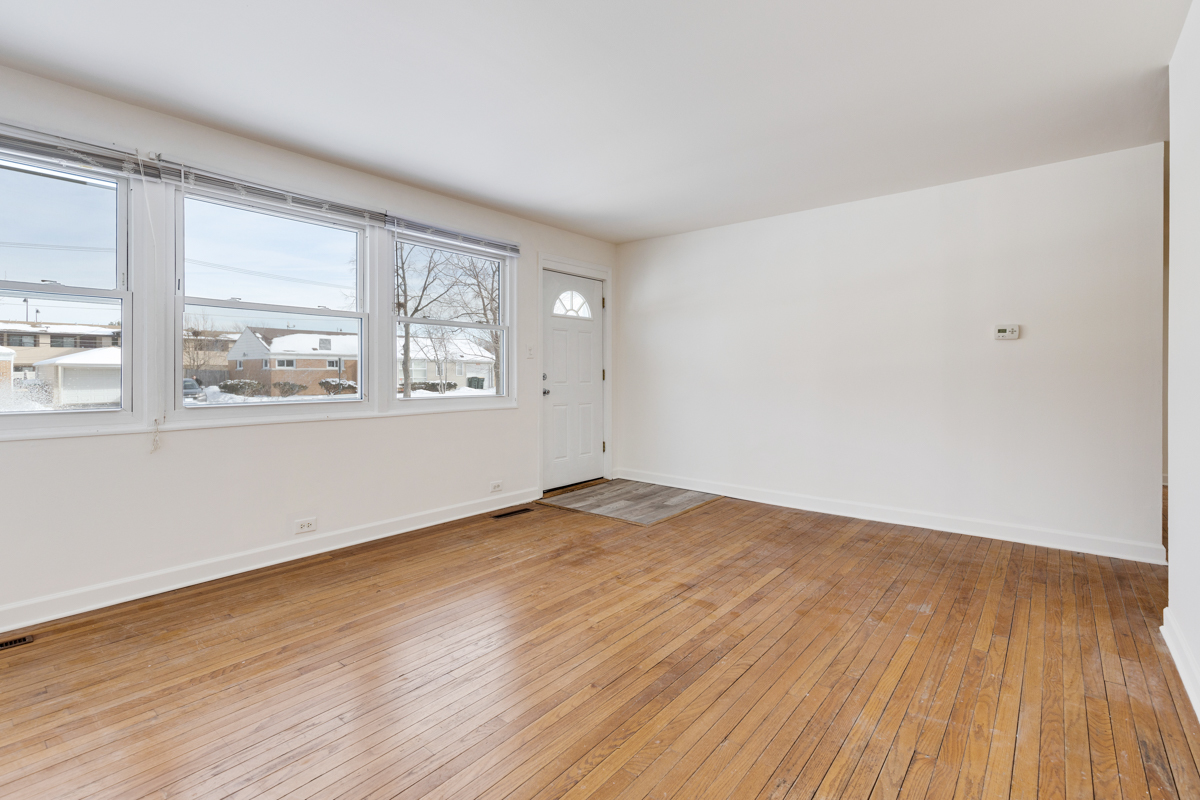 9432 Sayre Avenue Morton Grove, IL 60053 - Photo 3 of 20 an empty room with wooden floor and windows