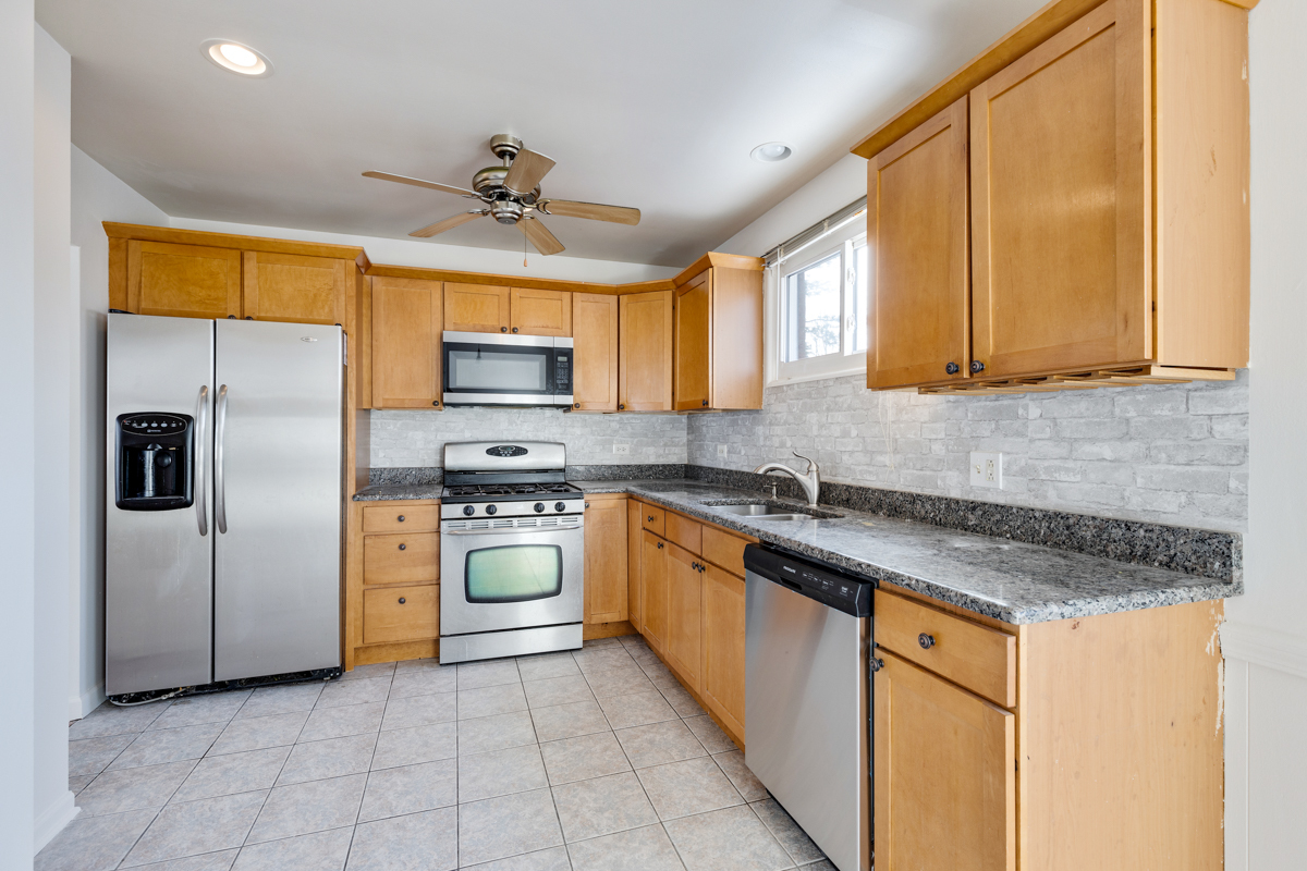 9432 Sayre Avenue Morton Grove, IL 60053 - Photo 4 of 20 a kitchen with stainless steel appliances granite countertop a stove a sink and a refrigerator