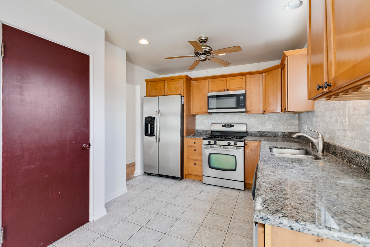 9432 Sayre Avenue Morton Grove, IL 60053 - Photo 5 of 20 a kitchen with stainless steel appliances granite countertop a refrigerator a stove top oven a sink and dishwasher