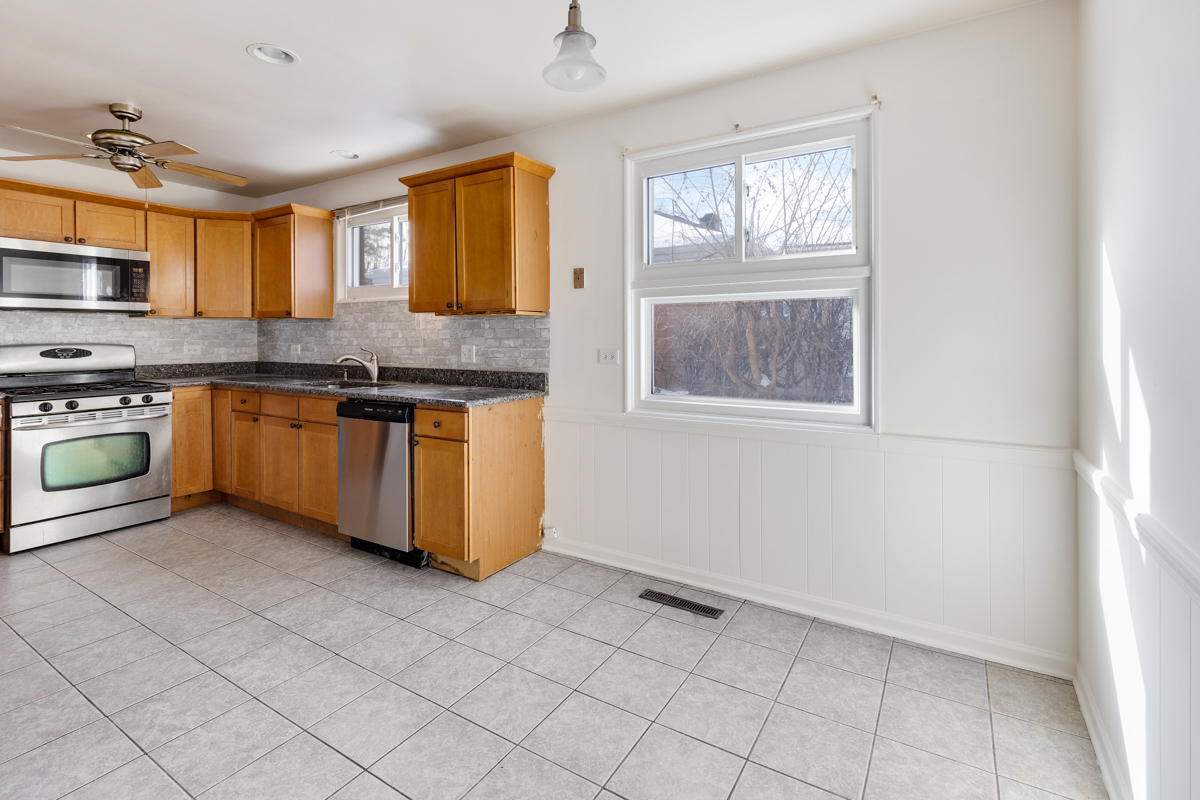 9432 Sayre Avenue Morton Grove, IL 60053 - Photo 6 of 20 a kitchen with stainless steel appliances granite countertop a stove a sink and a refrigerator