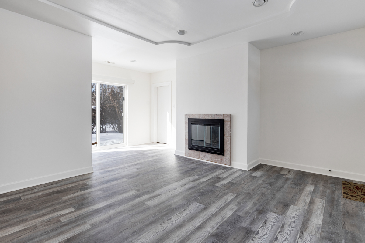 9432 Sayre Avenue Morton Grove, IL 60053 - Photo 8 of 20 a view of an empty room with wooden floor fireplace and a window