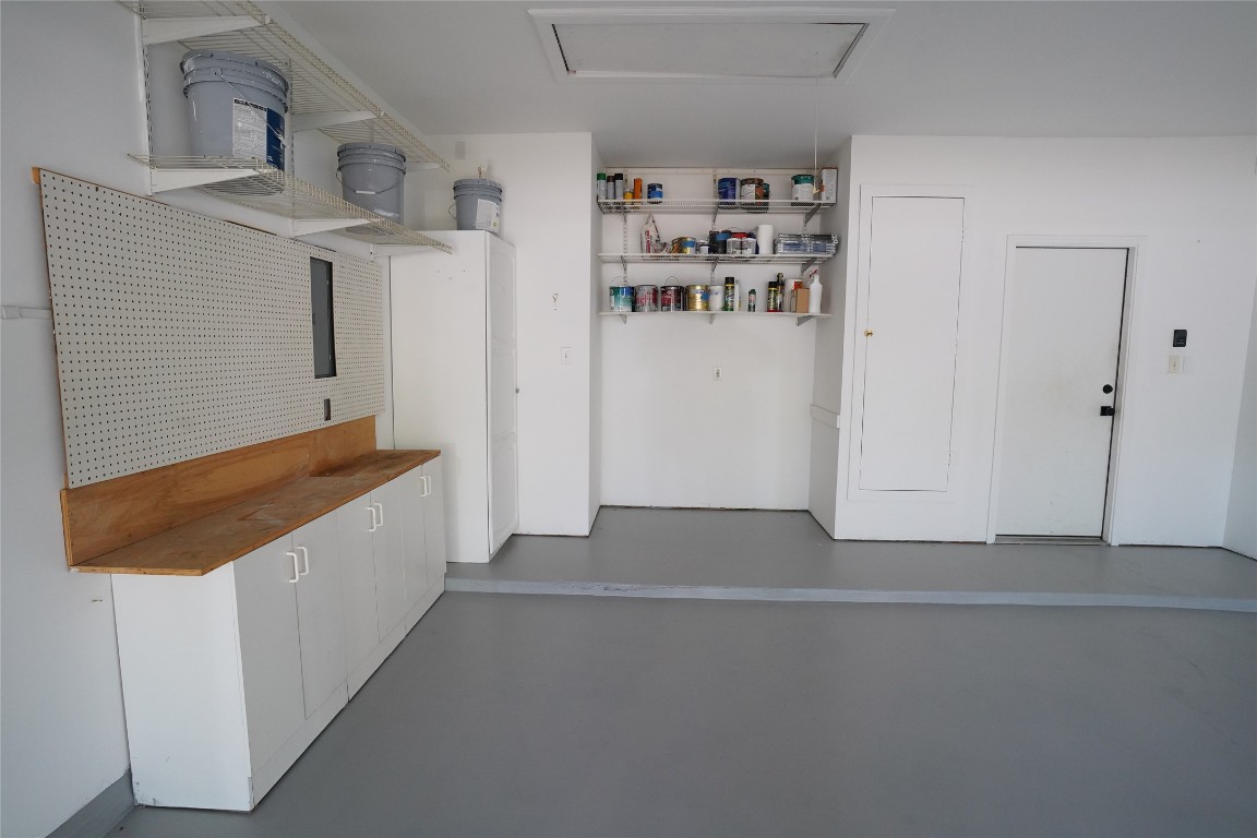 1712 Hackney Cove Austin, TX 78727 - Photo 35 of 38 Garage with built in work bench and extra space for storage. The attic is floored for lots of storage space as well as outlets/power.