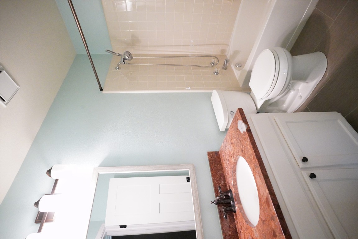1712 Hackney Cove Austin, TX 78727 - Photo 38 of 38 a bathroom with a granite countertop sink toilet a mirror and shower