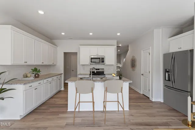 a kitchen with granite countertop a refrigerator stove microwave and cabinets