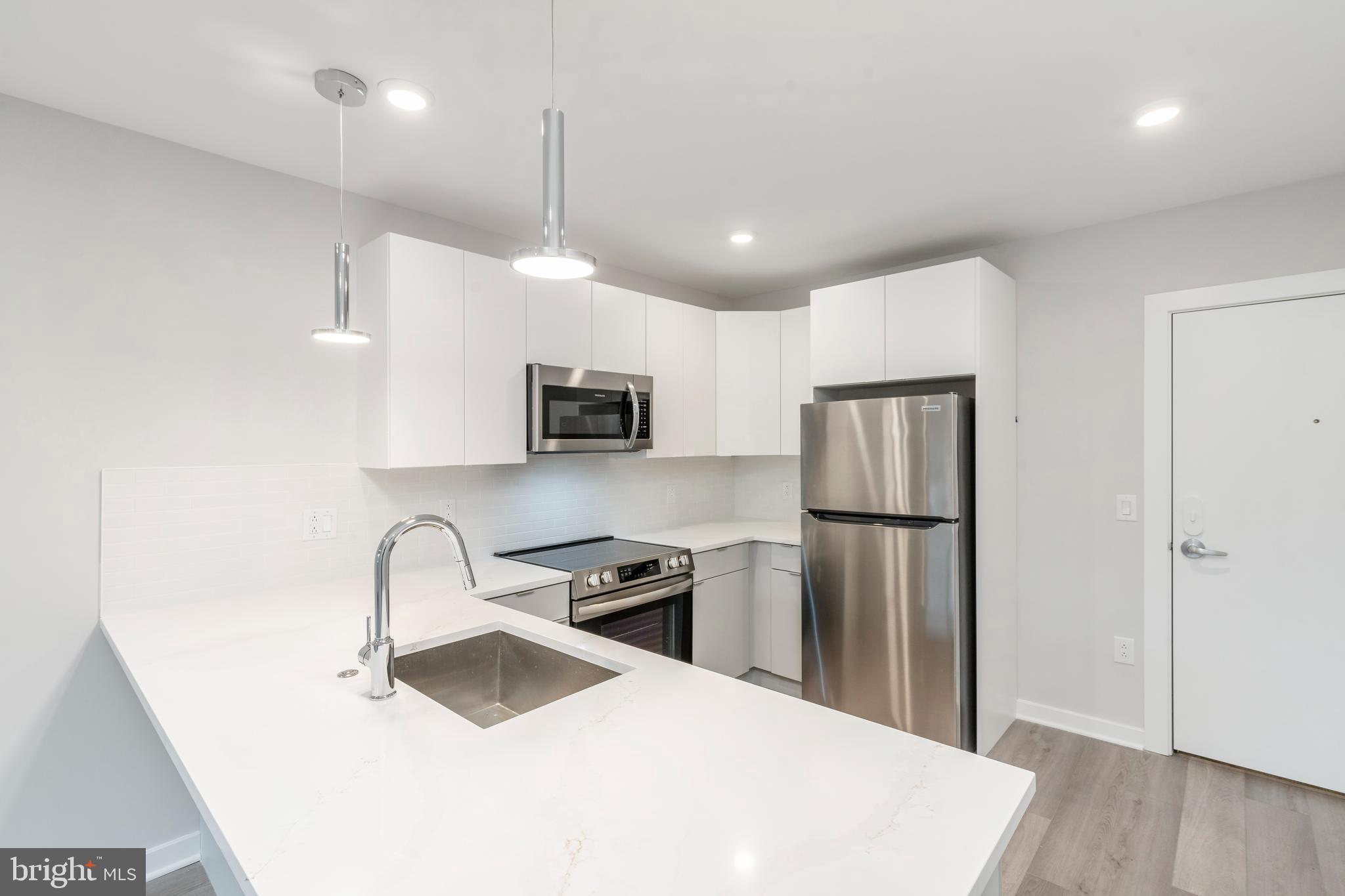 a kitchen with stainless steel appliances a refrigerator sink and microwave