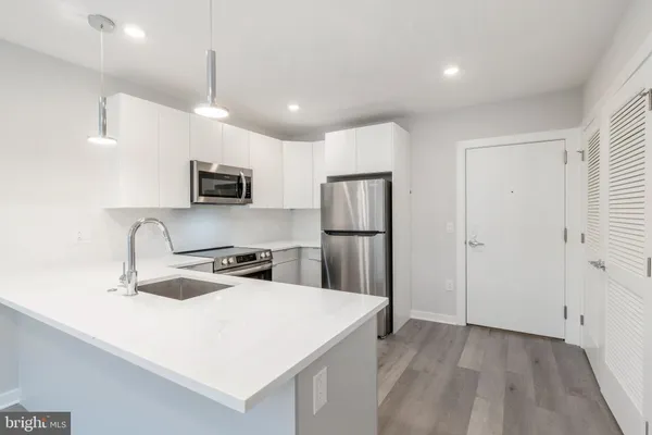 a kitchen with kitchen island a sink appliances and cabinets