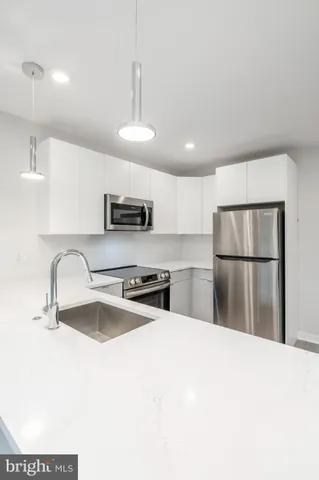 a kitchen with stainless steel appliances granite countertop a refrigerator a sink a stove a microwave a sink and a refrigerator