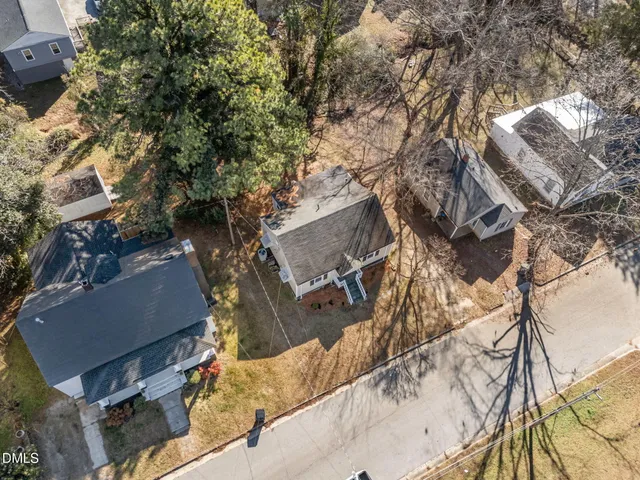 an aerial view of a house with a yard and wooden fence