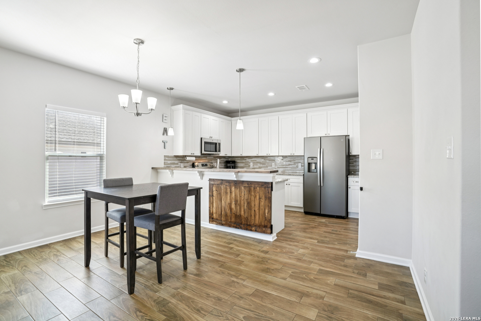 156 Remington Road Spring Branch, TX 78070 - Photo 10 of 32 a kitchen with stainless steel appliances a dining table chairs stove refrigerator and cabinets