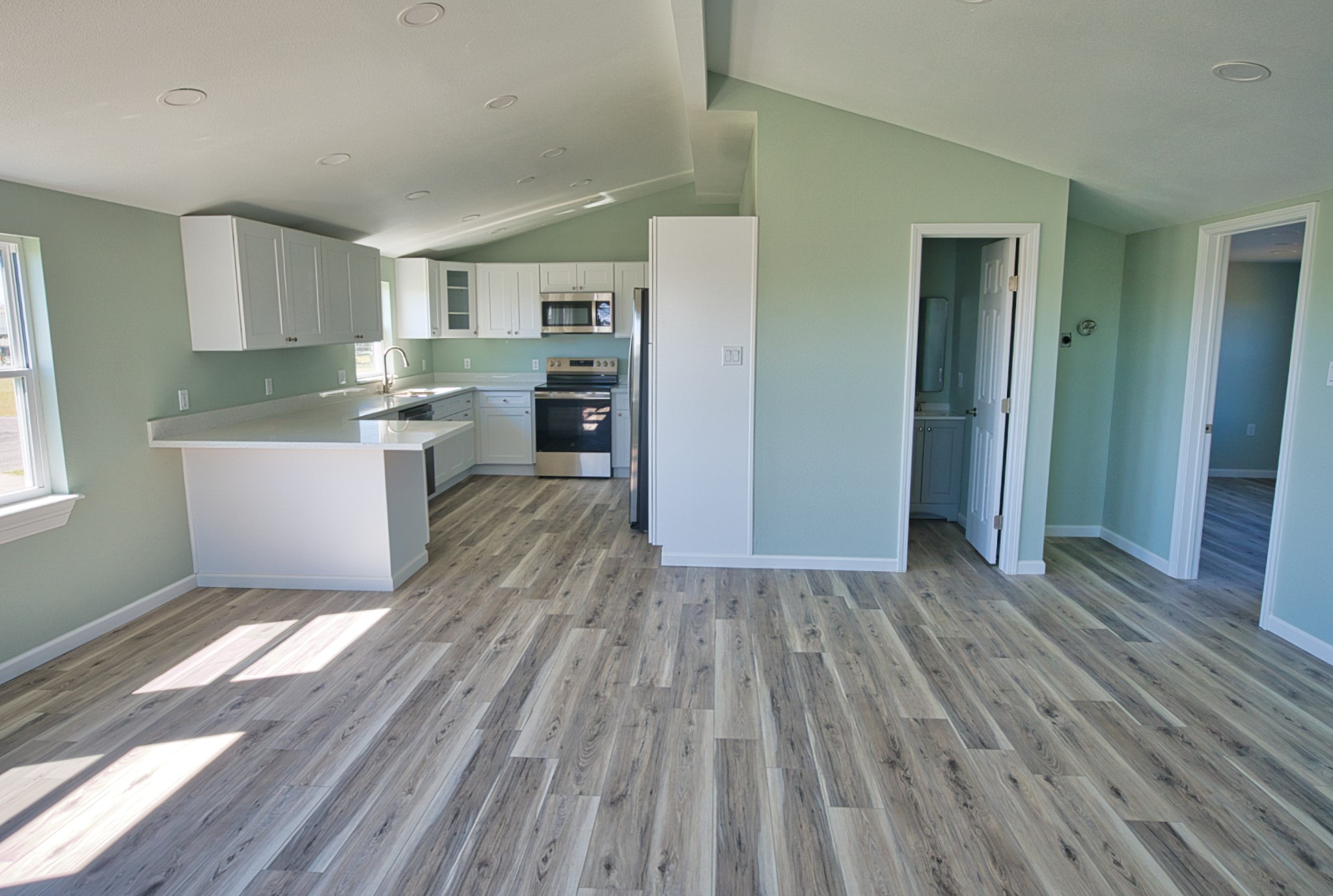 976 County Road 201 Sargent, TX 77414 - Photo 14 of 40 Guest bathroom to the right of the kitchen and a dedicated space for a full-size stackable washer and dryer!
