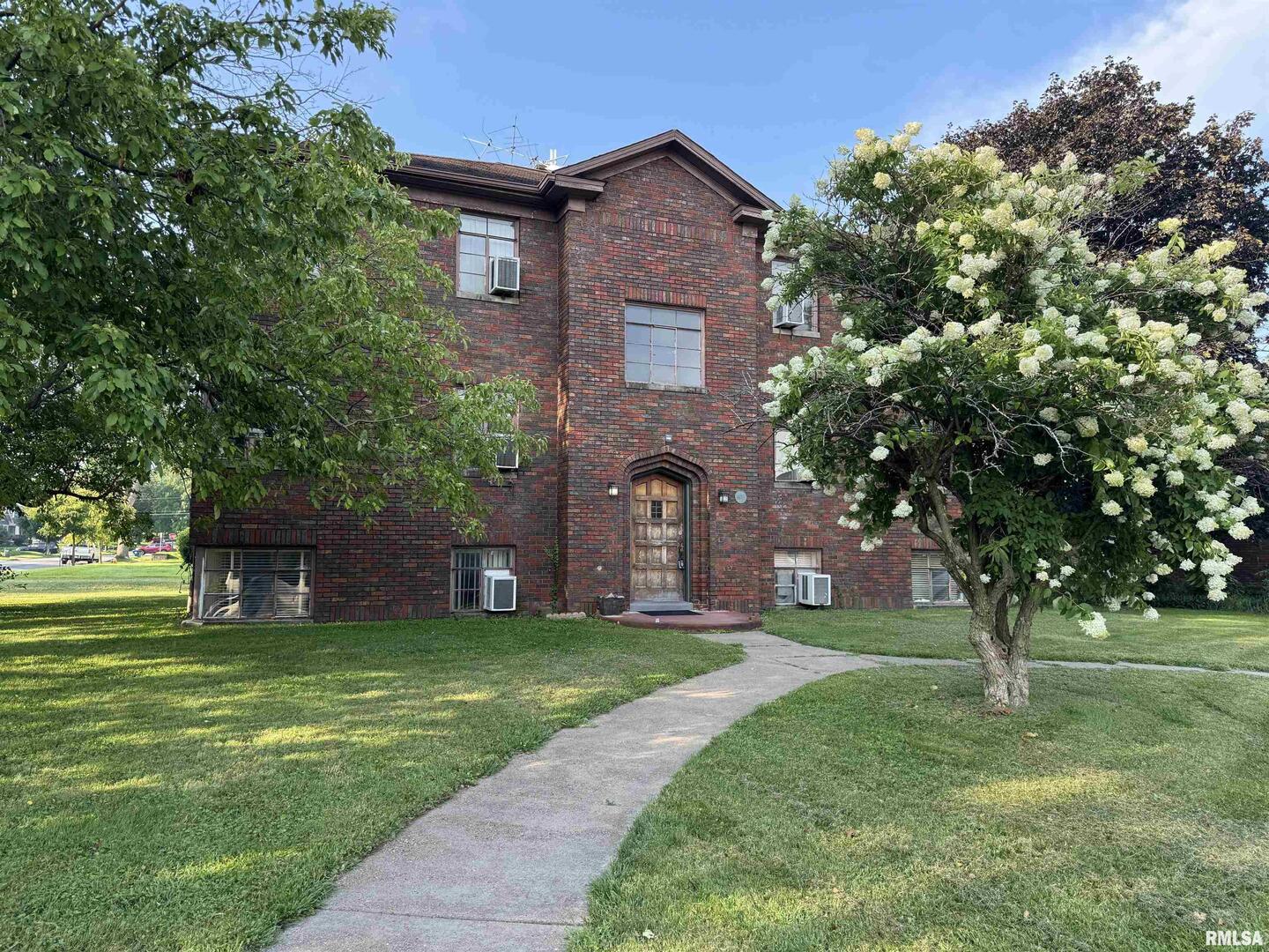 405 West Columbia Avenue, Unit 6 undefined, IA 52803 - Photo 1 of 12 a view of a brick house with a big yard and large trees