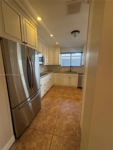 a kitchen with granite countertop a refrigerator and a sink