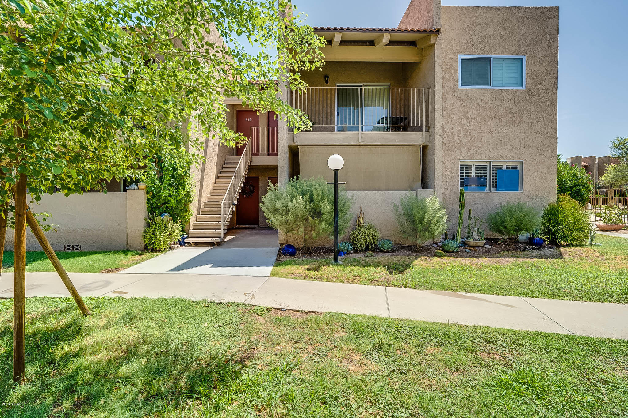 5525 East Thomas Road, Unit R12 Phoenix, AZ 85018 - Photo 1 of 14 a front view of a house with a yard and a garage