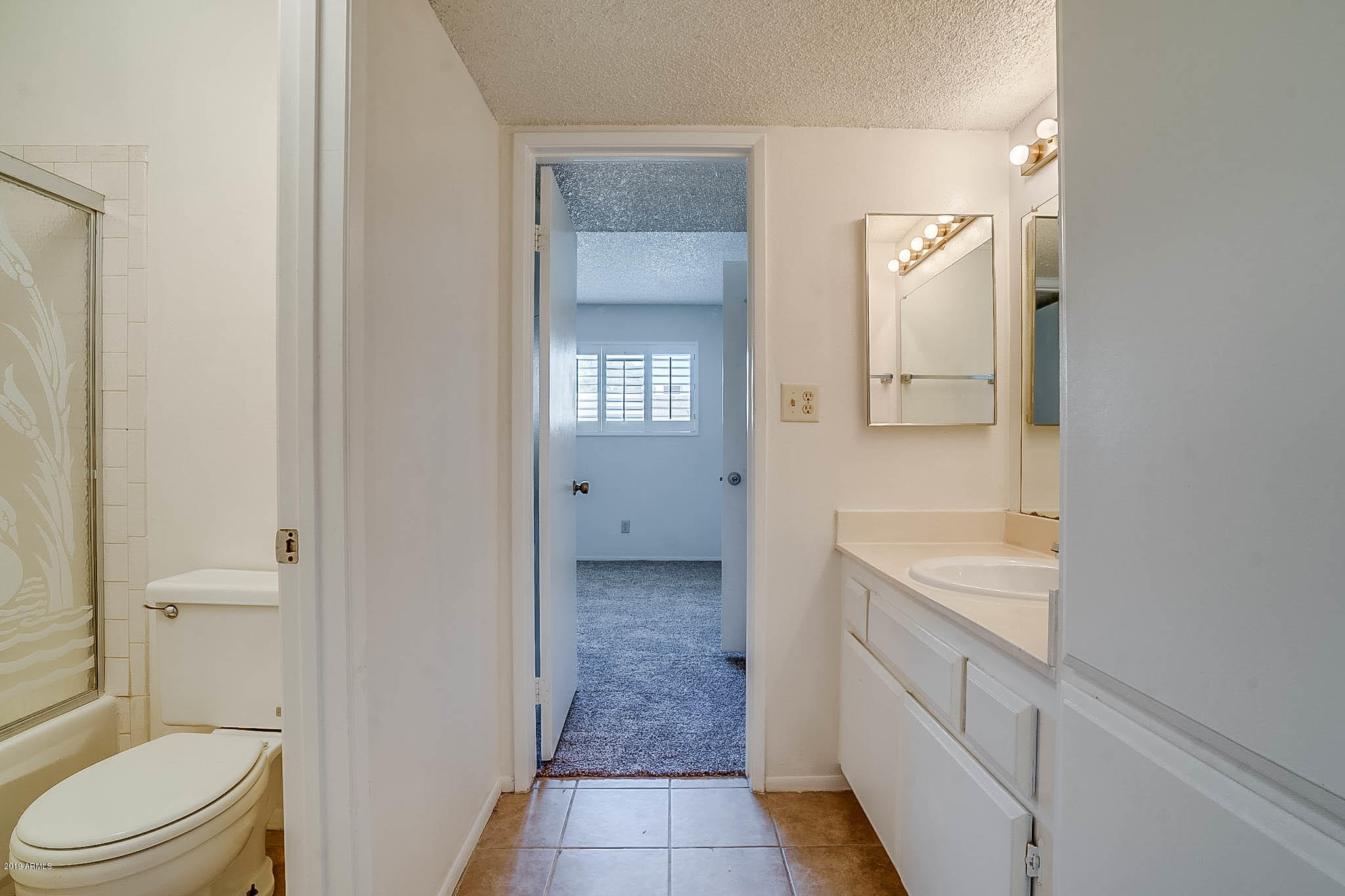 5525 East Thomas Road, Unit R12 Phoenix, AZ 85018 - Photo 4 of 14 a bathroom with a granite countertop sink a toilet and shower