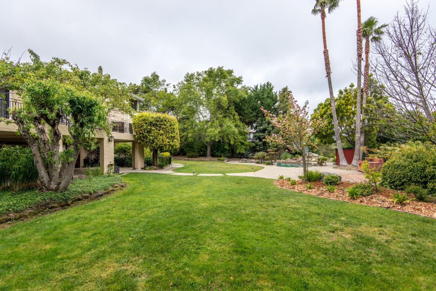 760 Darrell Road Hillsborough, CA 94010 - Photo 28 of 35 a view of a house with a big yard and potted plants