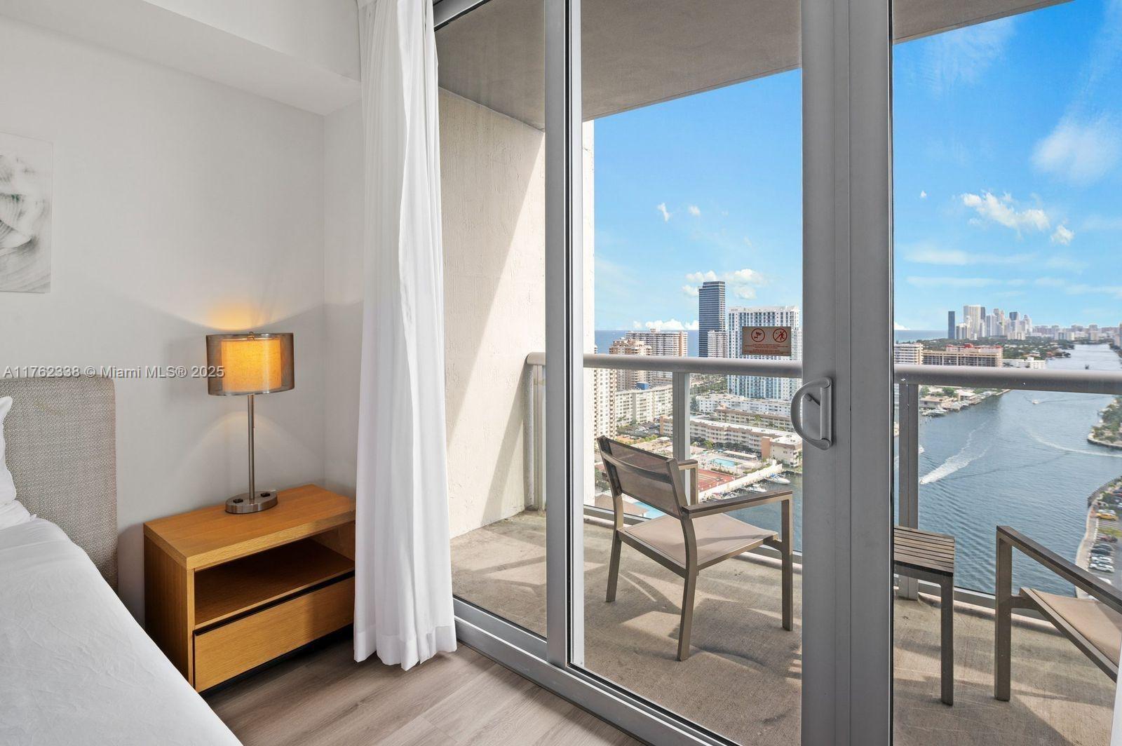 2602 East Hallandale Beach Boulevard, Unit R2703 Hallandale Beach, FL 33009 - Photo 14 of 50 a bedroom with furniture and a window