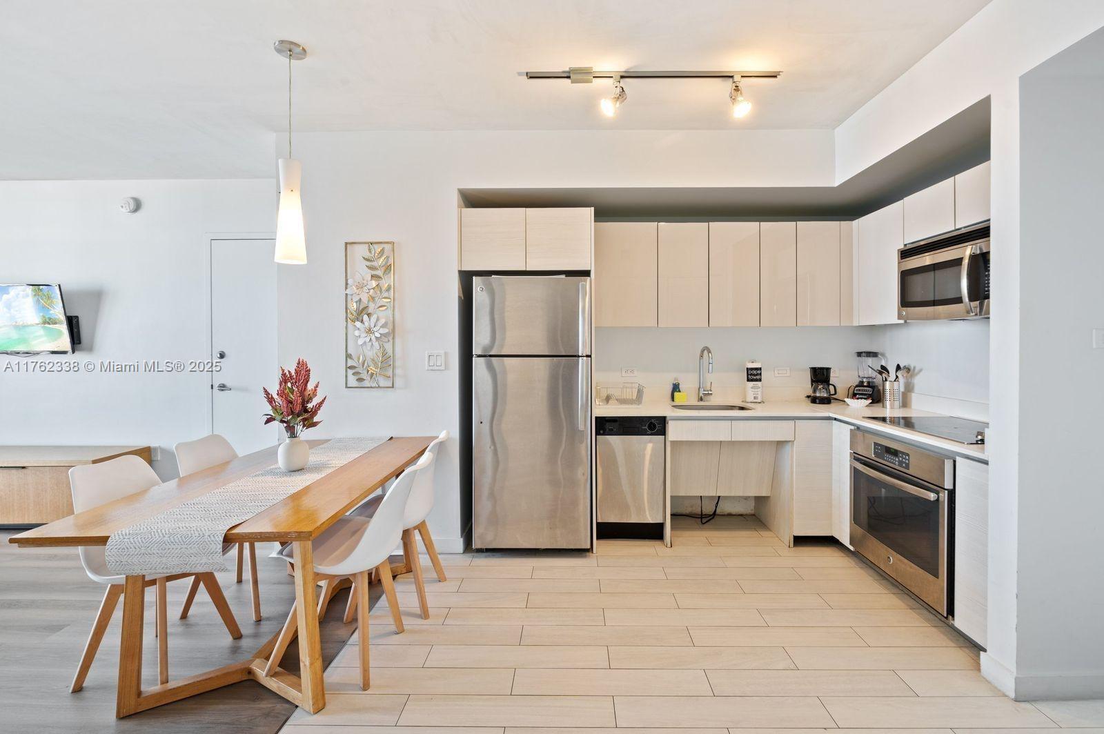 2602 East Hallandale Beach Boulevard, Unit R2703 Hallandale Beach, FL 33009 - Photo 15 of 50 a kitchen with white cabinets and stainless steel appliances