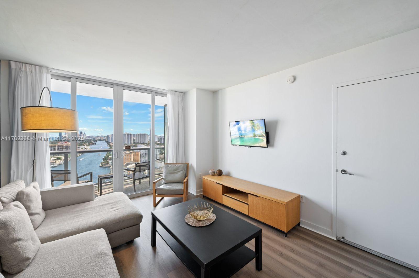 2602 East Hallandale Beach Boulevard, Unit R2703 Hallandale Beach, FL 33009 - Photo 24 of 50 a living room with furniture and a lamp