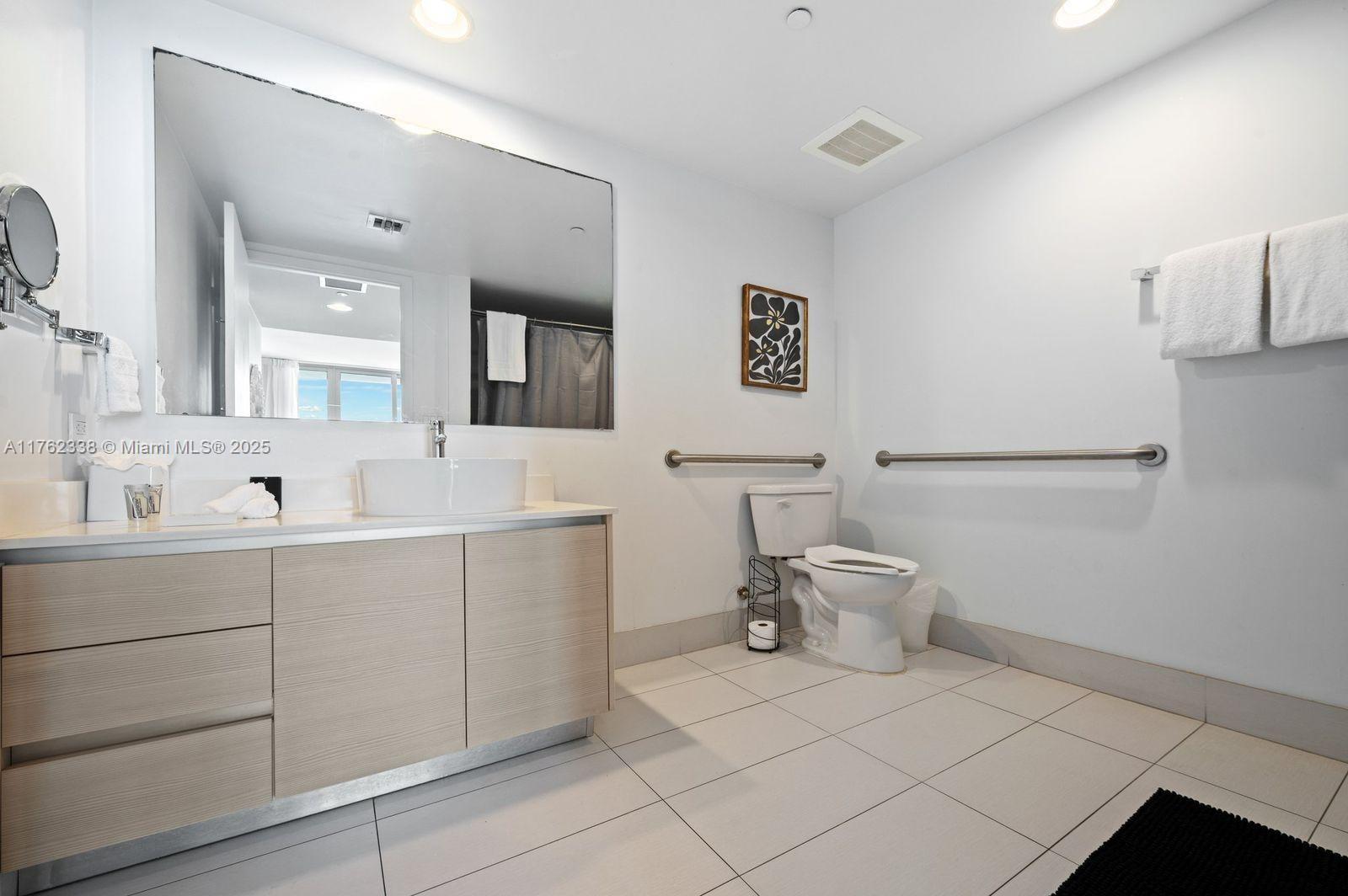 2602 East Hallandale Beach Boulevard, Unit R2703 Hallandale Beach, FL 33009 - Photo 32 of 50 a spacious bathroom with a double vanity sink and a mirror